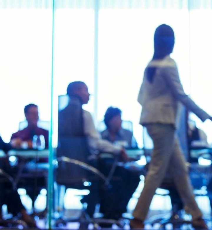 People sit at a boardroom table.