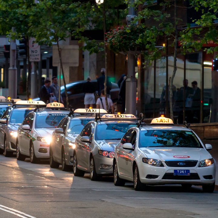 A line of taxis in the city at dusk