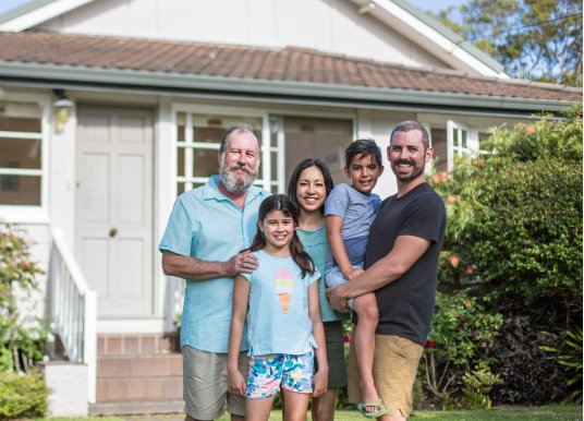 Multi-generational family pictured in front of a home